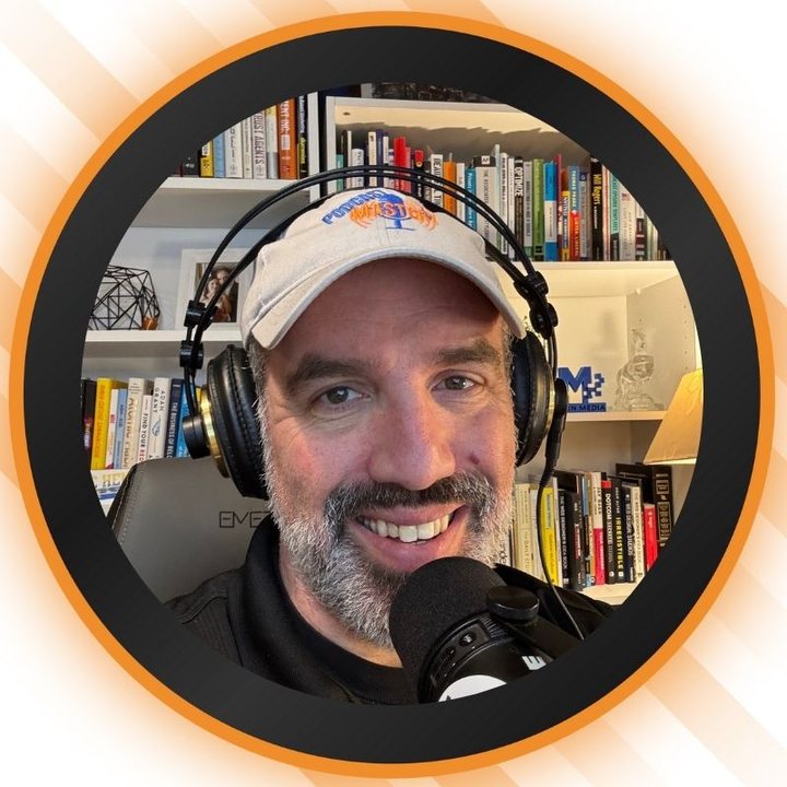 Host of Podcast Mastery wearing headphones and a Podcast Mastery cap, smiling at the microphone